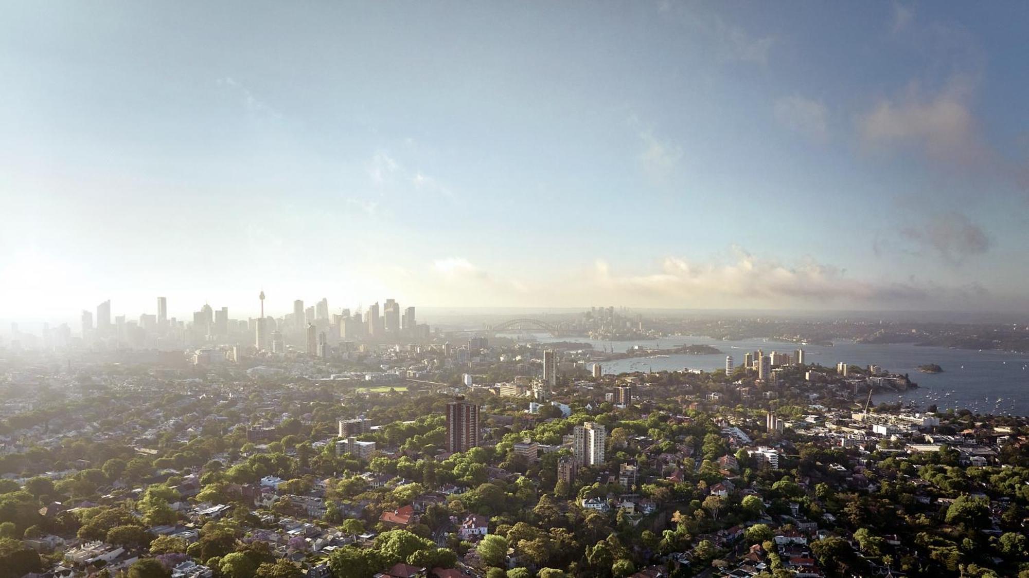 Meriton Suites Bondi Junction Sídney Exterior foto The photo shows a panoramic view of a city skyline, likely taken from a high vantage point. In the foreground, there are lush green trees and buildings, suggesting a suburban area. As the view extends towards the background, tall skyscrapers dominate